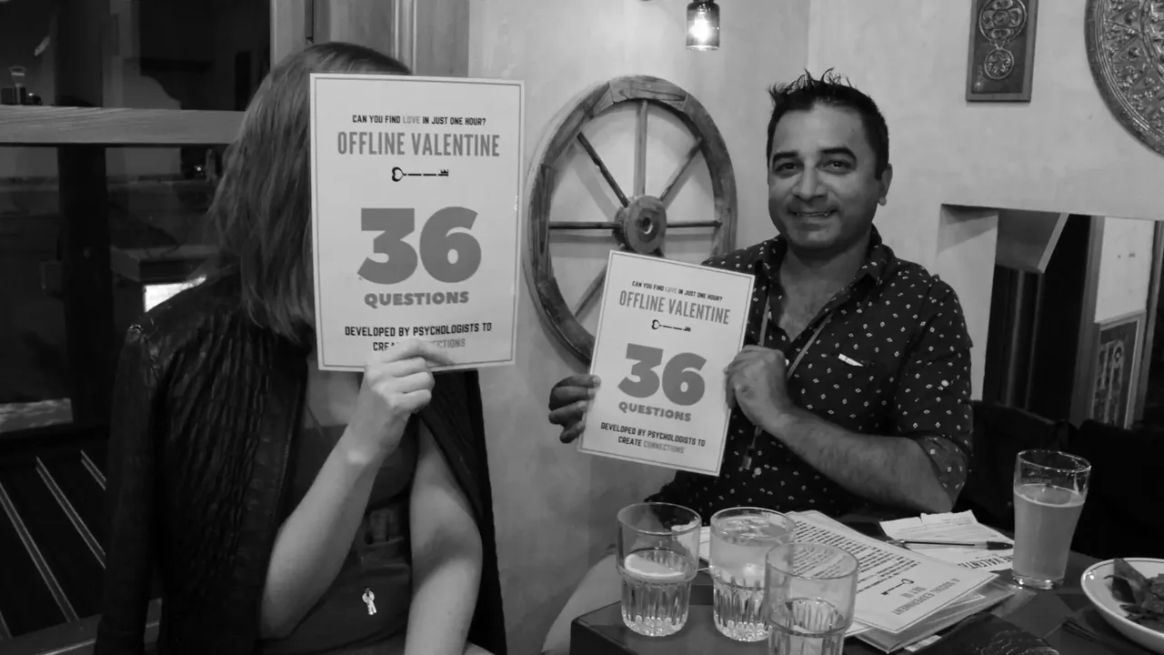 Two guests holding the 36 Questions sheets